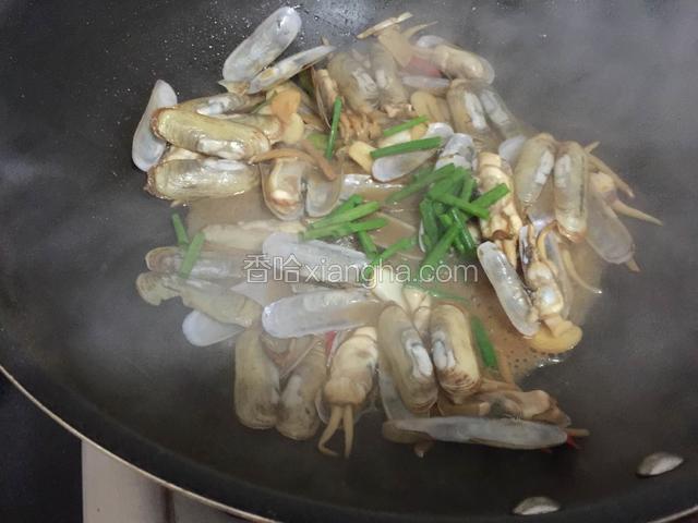 待所有的蛏子壳都打开了，蛏子也熟了。出锅撒上葱绿和少许的糖炒匀即可出锅。