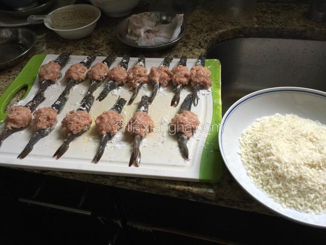 将肉馅十虾肉打成泥加调料制成馅，捏成团酿在虾身中间。将蛋打散，取酿好的虾先浸蛋液，再上生粉，再浸蛋液，最后沾匀面包渣待用。