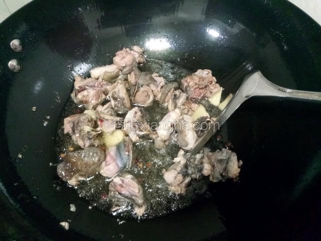 下入鸡块和几片姜，爆干鸡肉水分。