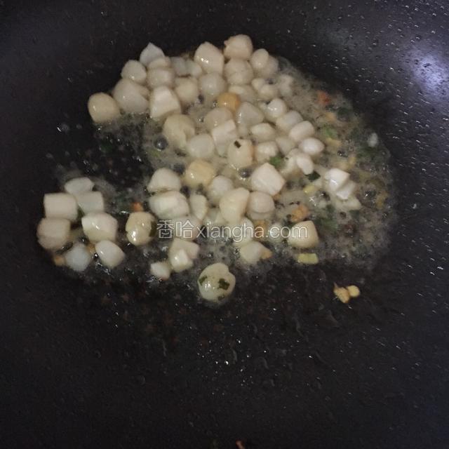 炝锅油热至七成后倒入腌制好的鲜贝，大火爆炒至肉紧致。