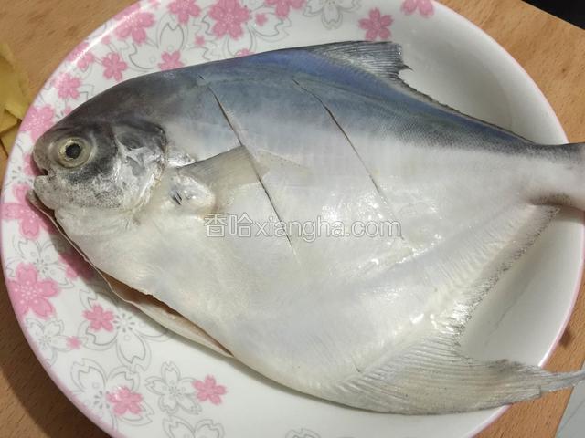 把鱼洗干净，分别在两面各划两刀。