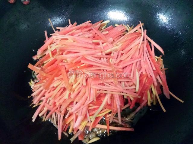 放入胡萝卜丝，翻炒至胡萝卜丝均匀浸润后。