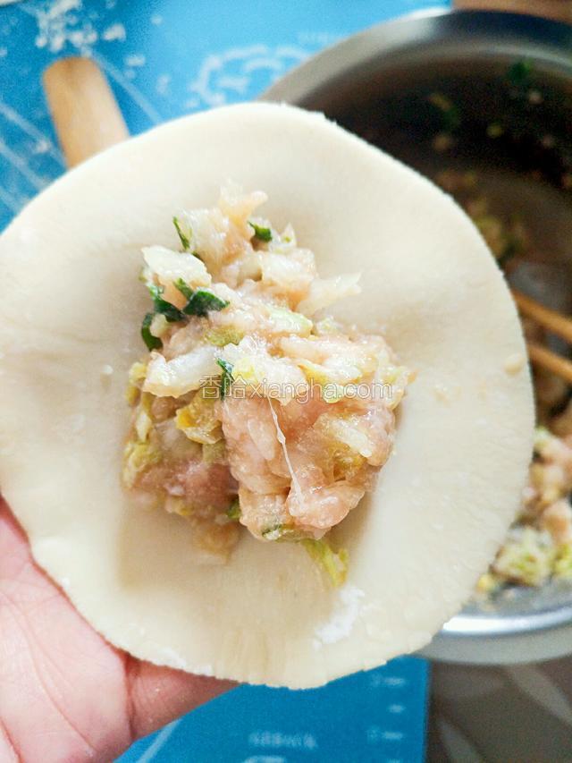 取饺皮，放上馅料包好