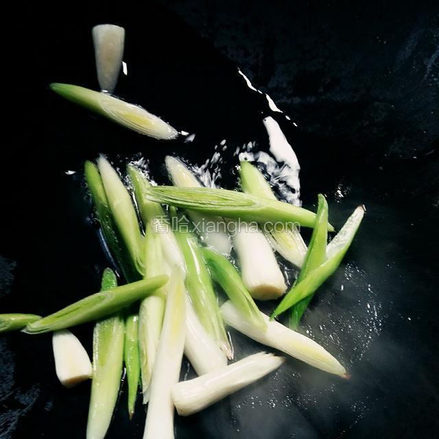 热锅凉油，放入部分蒜白，爆香