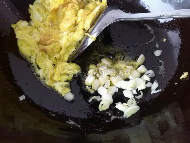 蛋拨一边，放葱花炒香