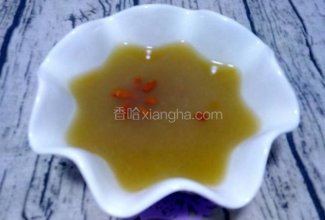 倒出苹果汁并用勺子去掉表面的泡沫，放入几粒枸杞作为装饰。