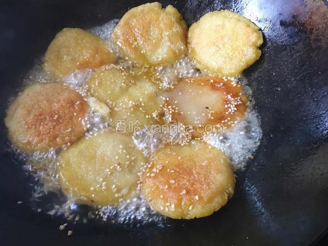 把芝麻糖水倒入锅中和煎好的粑粑混合。