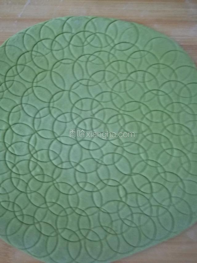 用一块绿色的面团擀成薄片，用瓶子盖轧龟背纹路。都压好后。
