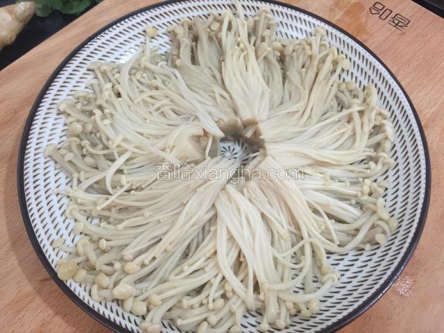 把蒸好的金针菇倒去多余的水，摆入盘中。