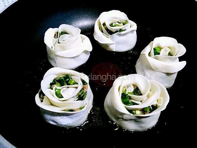 整理一下饺子的边缘，使之形似玫瑰花（我漏拍了一张成型图）锅中加入少许橄榄油，把饺子依次摆好