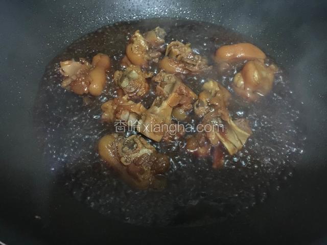 把煮好的猪蹄连汤倒入炒锅里，开大火收汁。