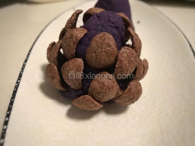 在紫薯泥塔的底部插一圈巧克力麦片，然后依次往上插。