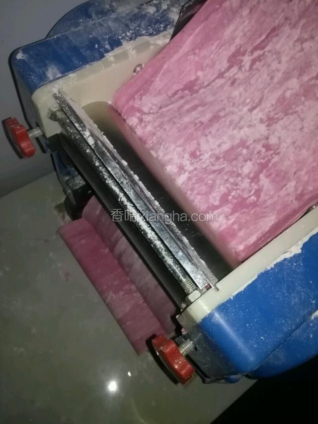 将面条机通电，将和好的面放入面条机开始轧面皮