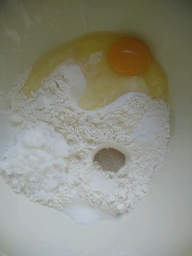 准备面粉放入盆里，打入一个鸡蛋，放入白糖，酵母，盐，小苏打