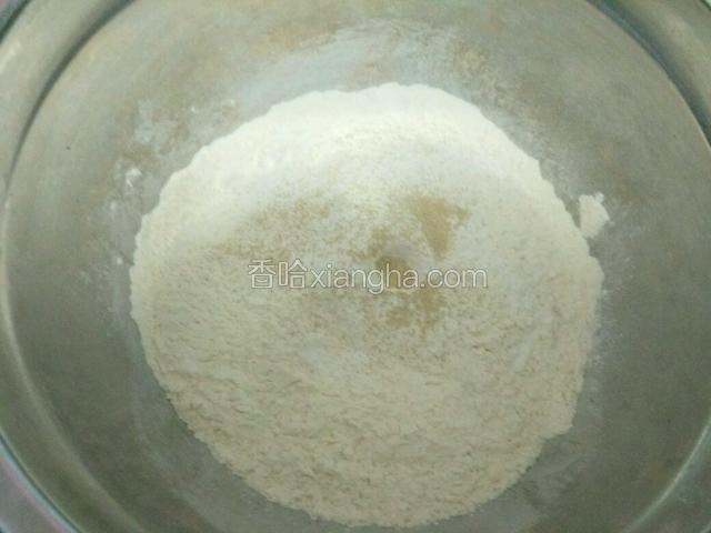 制作包子皮，盆里放入面粉，酵母粉，泡打粉，用大致35度的温水慢慢倒入，和面。