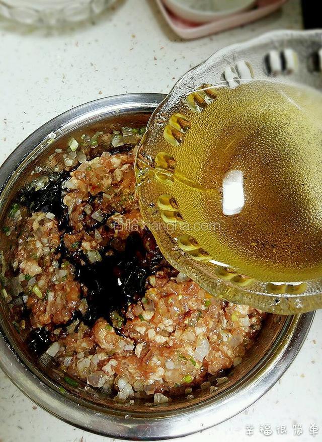 滤出的花椒水分多次倒入馅料中，按顺时针方向打匀肉馅。