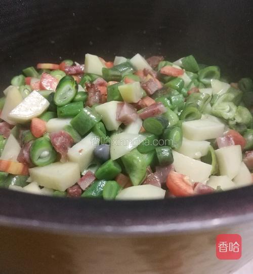 然后把炒得小半熟的菜倒入电饭锅里。也可以直接倒进炒锅里。