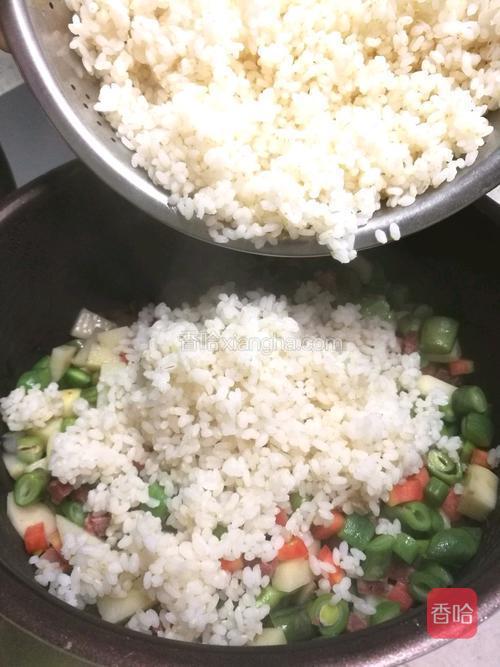 把刚才沥起来的米饭盖到菜上面，稍微倒入一点点水。