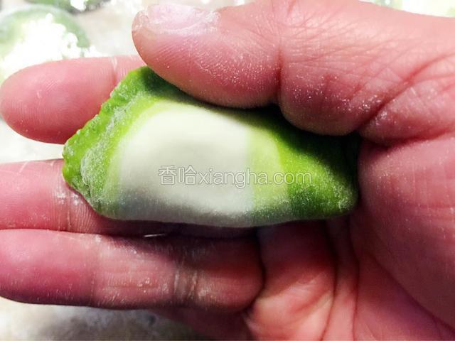 饺子的右角放到大拇指根部，食指和大拇指随着饺子皮边缘弯曲相随。左手同样对称的位置放好饺子双手用力均匀忘里一窝。（这时的力度是用在饺子边缘的）