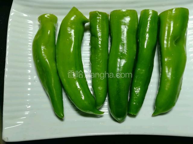将塞好肉的青椒摆在盘子上。