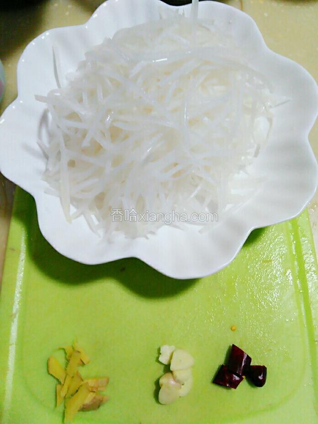 将萝卜切成丝。生姜.大蒜头.红辣椒切成粒。
