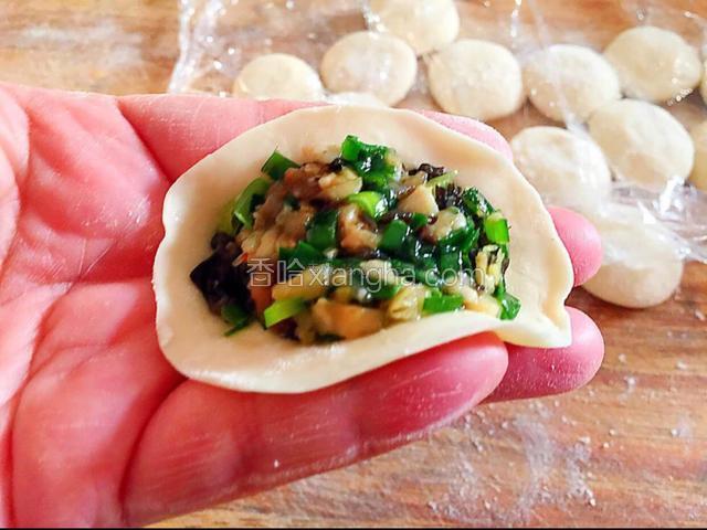 左手中指和无名指齐平，食指和小拇指高出中指和无名指，把饺子皮卡入中间放入肉馅。（饺子皮边缘不用留有馅料，不让会漏馅捏不住的）