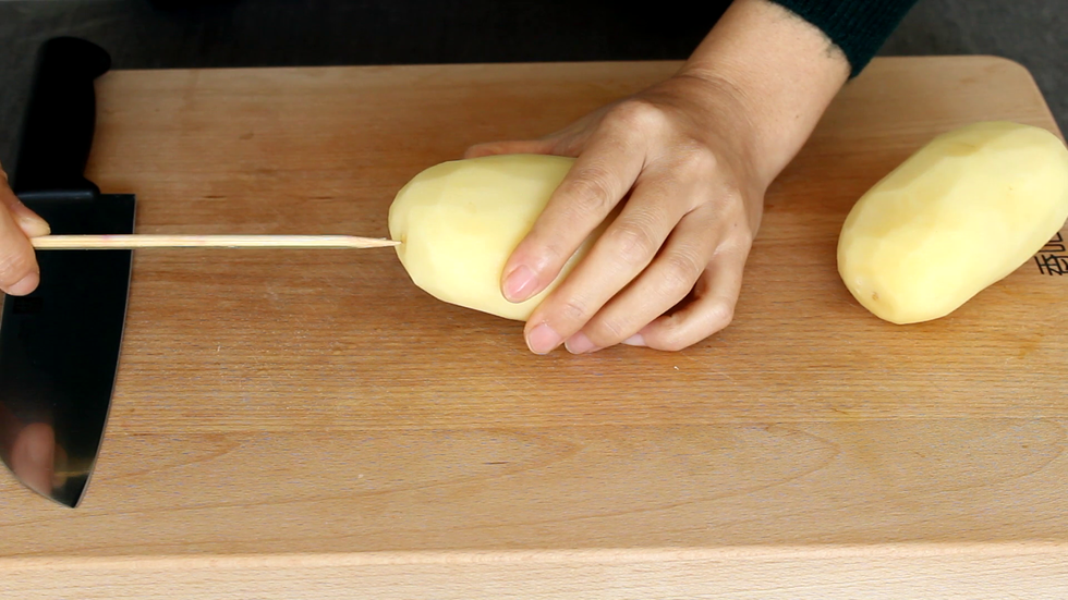 土豆去皮用竹签从一端扎入