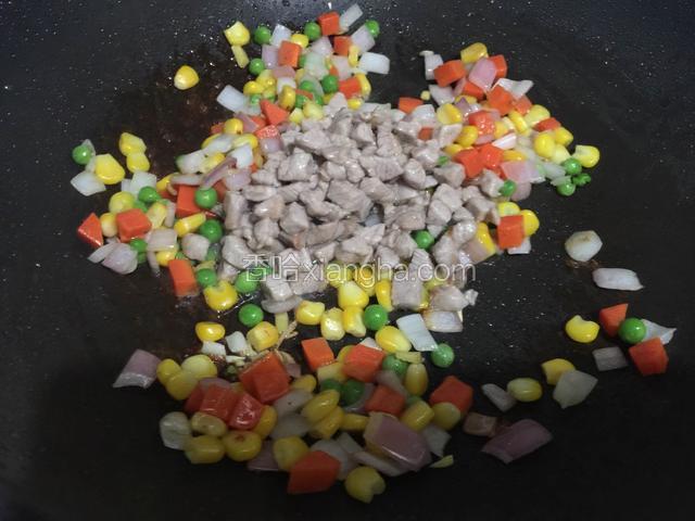 把青豆玉米胡萝卜和肉丁倒入一起翻炒半分钟。
