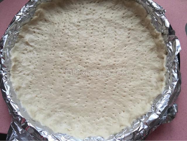 擀成面皮，铺进披萨盘里，用叉子扎些洞，入烤箱180度烤5分钟。