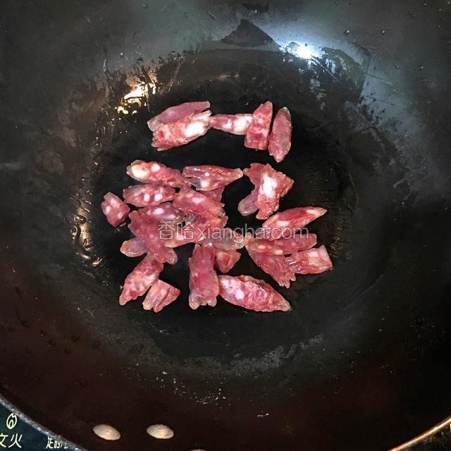 锅内放油，倒入腊肠炒至微焦