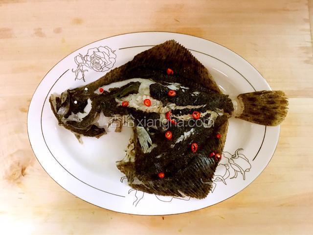 把蒸鱼水倒掉，把辣椒花撒到鱼身上点缀
