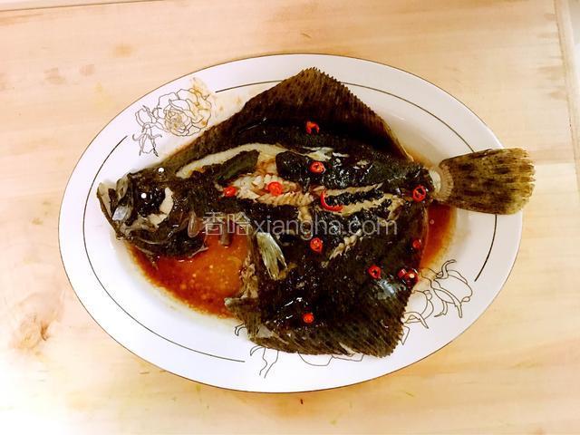 把加热的蒸鱼豉油倒在鱼身上：从鱼头到鱼尾浇一遍