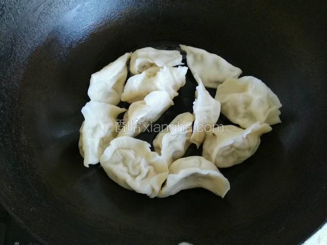 热油下锅将饺子码放整齐；
