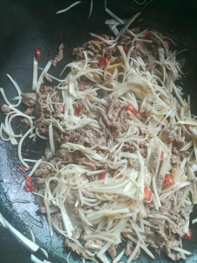 将牛肉丝倒入，与芋头丝一起翻炒。淋少许酱油，撒一丁点鸡精和葱花，炒匀出锅。