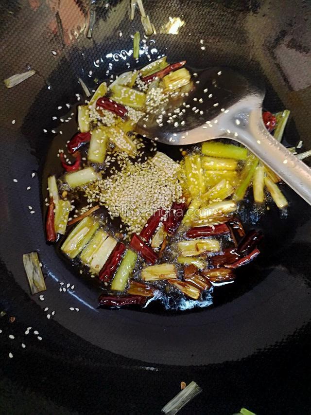 放入一点芝麻爆香，因为油很热，芝麻放进去就可以起锅了
