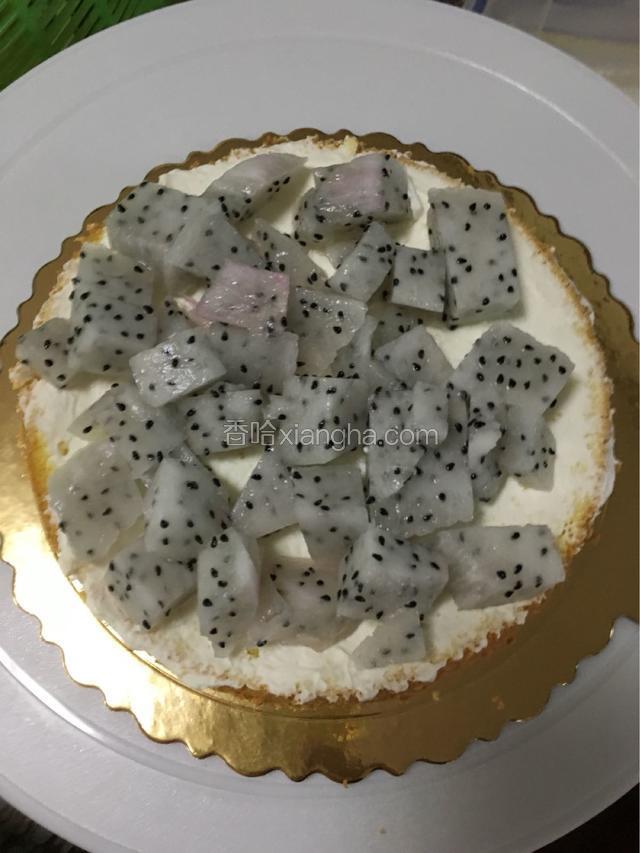 蛋糕用锯刀片成两片，取一片摸上奶油放上火龙果丁，另一片摸少许奶油盖上