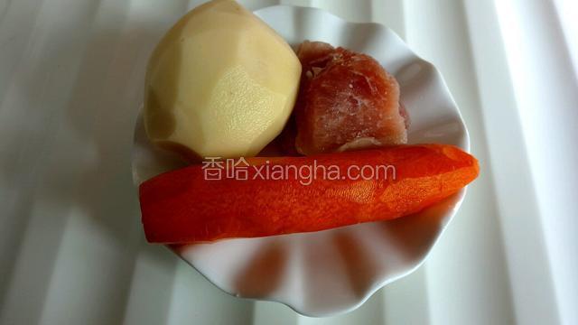 准备食材，将土豆、胡萝卜洗净并去皮，猪瘦肉洗净。