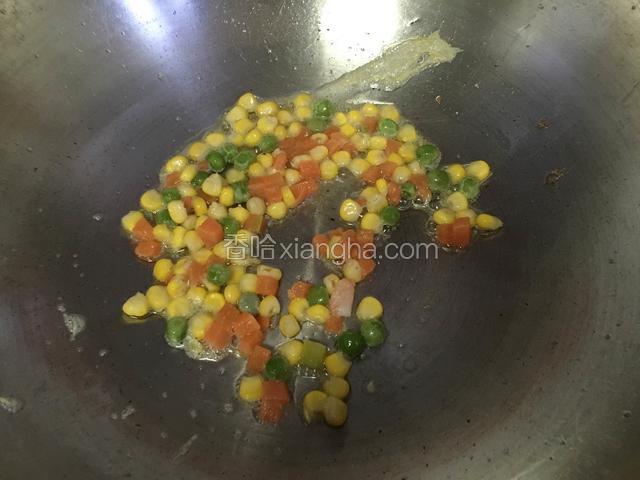 锅内放油烧热，下豌豆粒玉米粒和胡萝卜丁焯熟盛出。