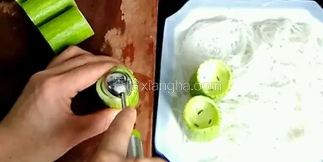 丝瓜用挖球器，挖出一半的瓜瓤，放在粉丝上面，一次摆整齐。