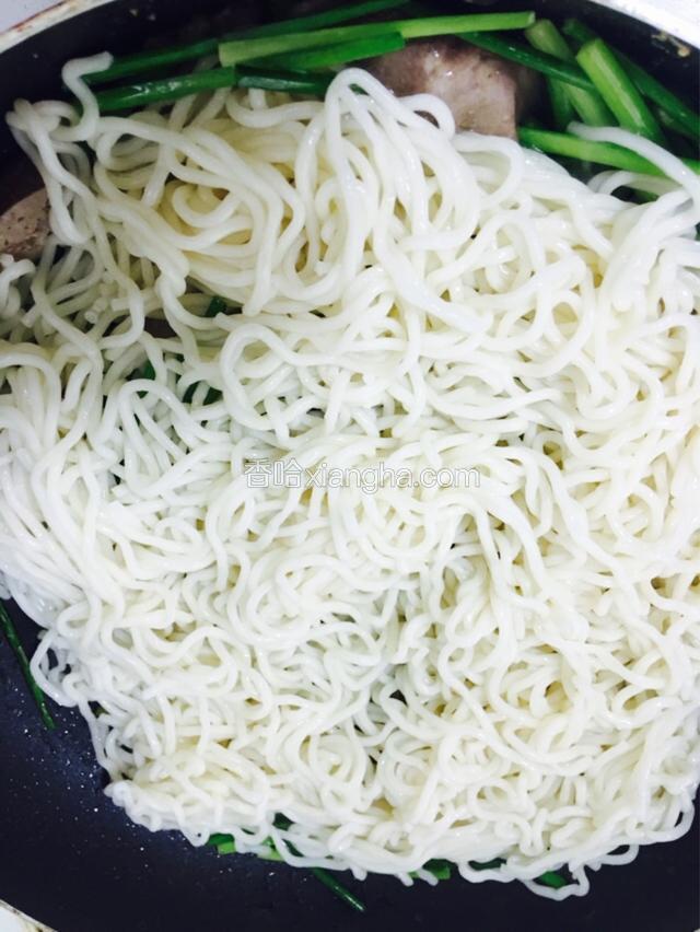 接着放入滤干水分的手工面条快速翻炒均匀。