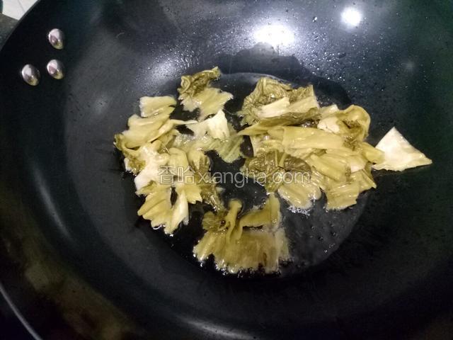 锅中放油下几粒花椒，放入酸菜炒香。这个过程中火慢炒，一定要等到泡酸菜的香味炒出来才行。