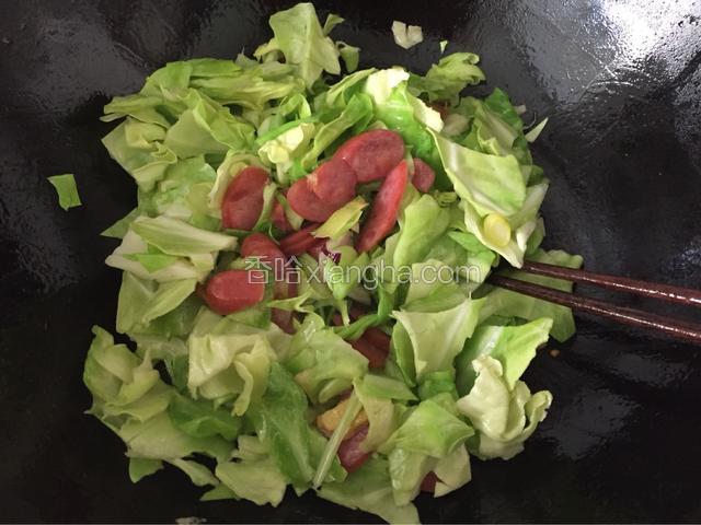 放入火腿肠、圆的菜翻炒片刻。