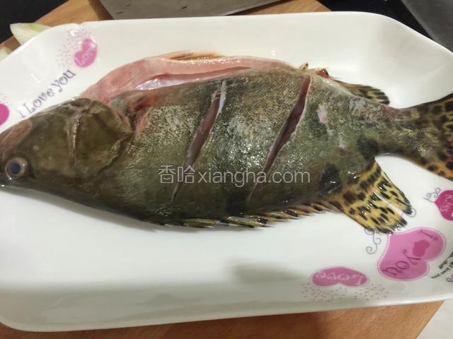 把鱼清洗干净，在鱼的两面各画两刀。