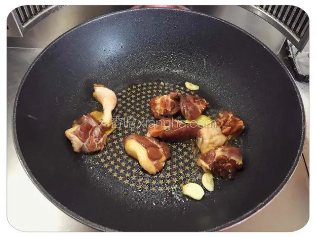 取锅加热，放油，放姜蒜煸炒出香味，然后放入腌好的鸭腿煸炒一会儿。