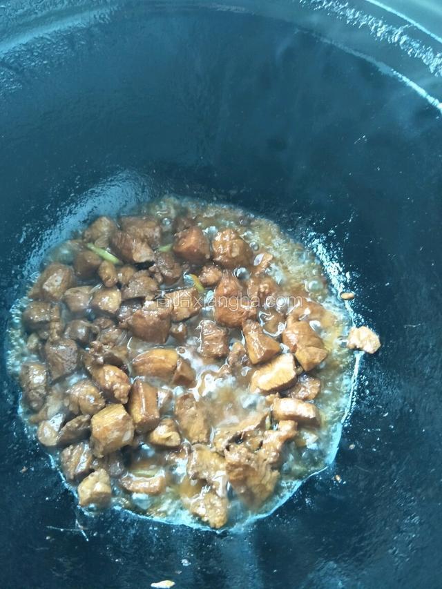 待油锅八成热时倒入腌制好的肉丁翻炒