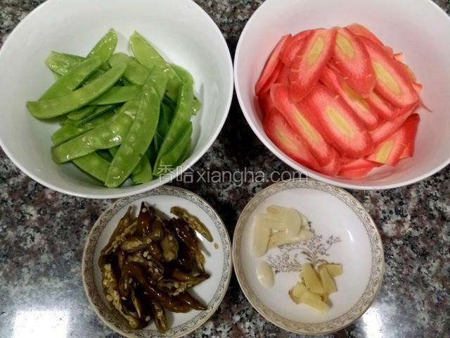 荷兰豆去两头和中间的筋清洗干净。胡萝卜清洗干净切薄片，实际我只切两个就够了。蒲海椒切丝，姜蒜切片。