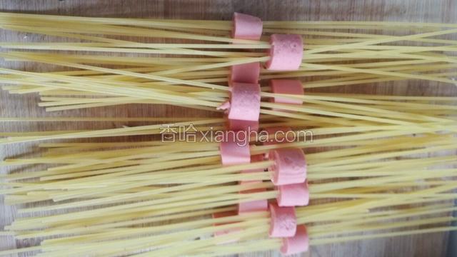 取意面从火腿穿过去，我是每个火腿穿六根意面。穿好。