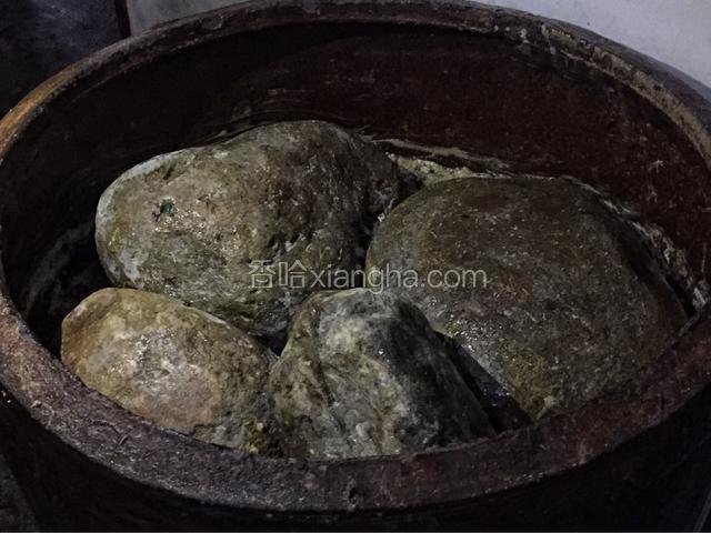 然后将菜放入腌菜的容器中，我腌的菜比较多，用了一口大缸，一层一层压结实，然后压上适当大小的鹅卵石即可。一两天后，菜就会出水，不用管，大约腌制半个月后就可以了！