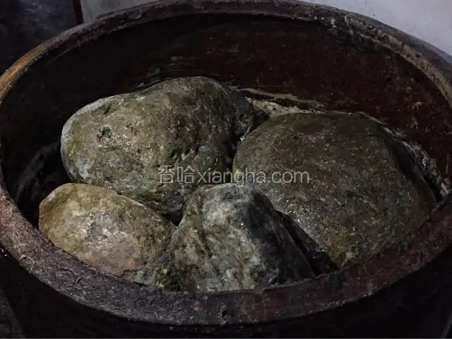 然后将菜放入腌菜的容器中，我腌的菜比较多，用了一口大缸，一层一层压结实，然后压上适当大小的鹅卵石即可。一两天后，菜就会出水，不用管，大约腌制半个月后就可以了！
