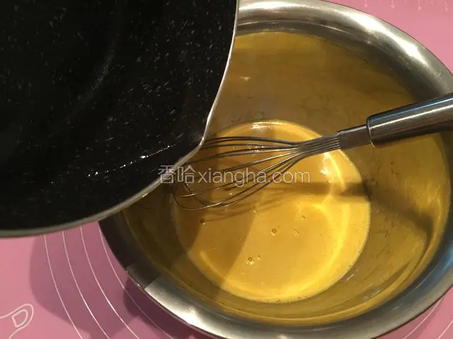 将糖水慢慢倒入蛋黄液中，边倒入边不停的搅打；